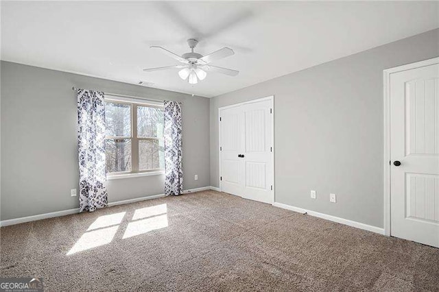 unfurnished bedroom featuring visible vents, baseboards, ceiling fan, carpet flooring, and a closet