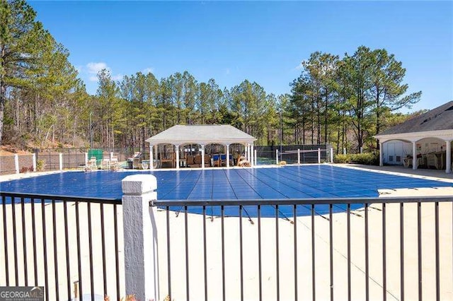 community pool with a gazebo and fence