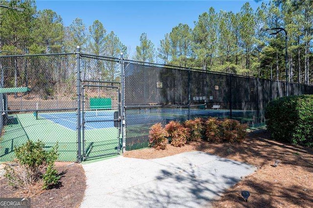 view of sport court with a gate and fence