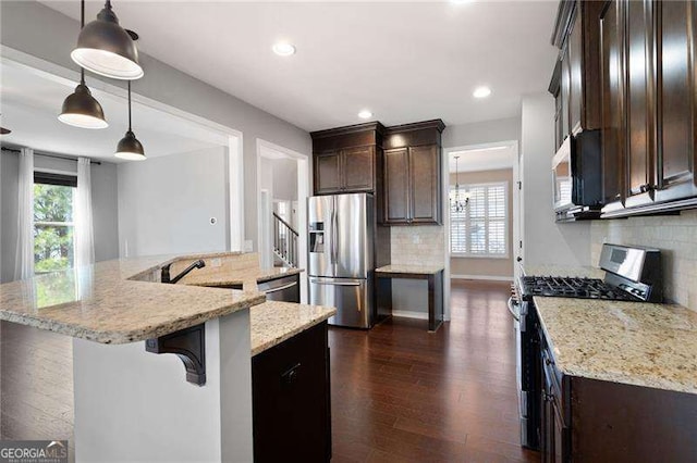 kitchen with stainless steel appliances, dark brown cabinetry, backsplash, and dark wood-style floors