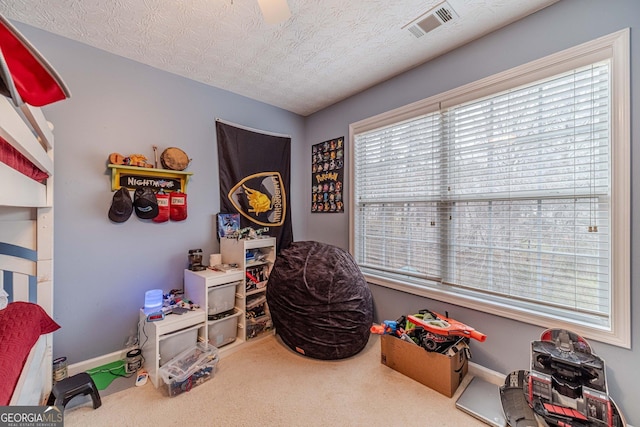 playroom with baseboards, carpet, visible vents, and a textured ceiling