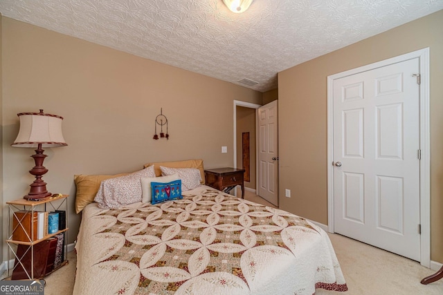 bedroom with visible vents, baseboards, light colored carpet, and a textured ceiling