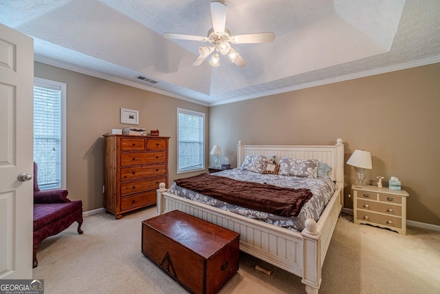 carpeted bedroom featuring baseboards, visible vents, a textured ceiling, crown molding, and a raised ceiling