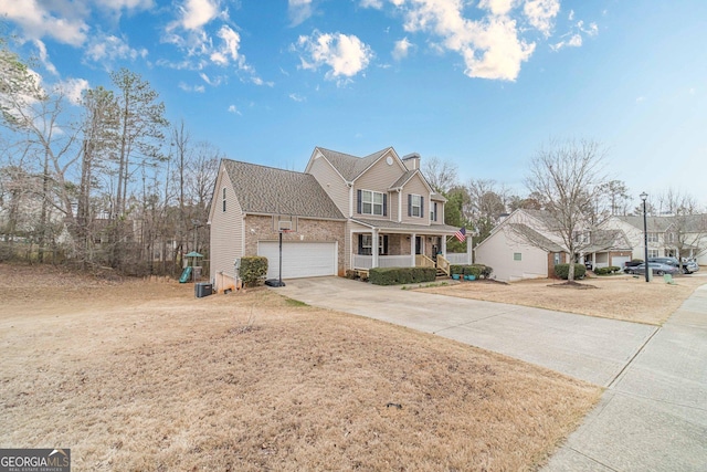 traditional-style home with a garage, covered porch, and driveway