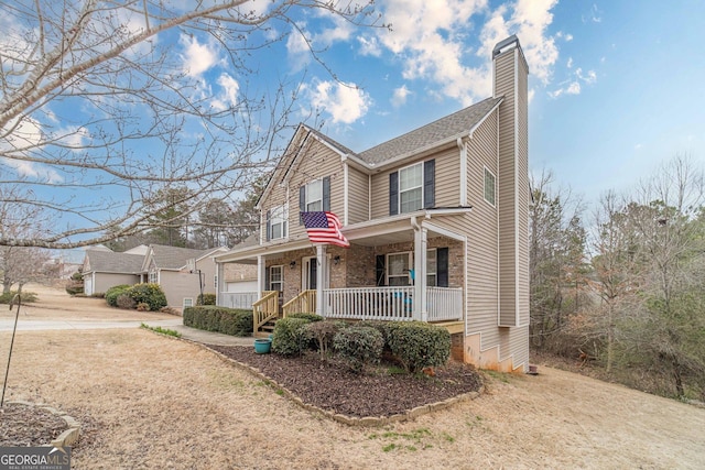 view of front of property with brick siding, covered porch, and a chimney