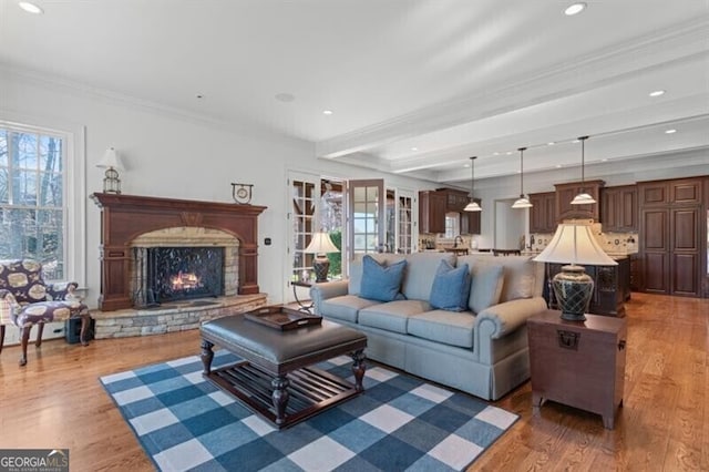 230 Hawks Lake Dr, Ball Ground, GA 30107 - living area featuring plenty of natural light, a lit fireplace, ornamental molding, wood finished floors, and recessed lighting