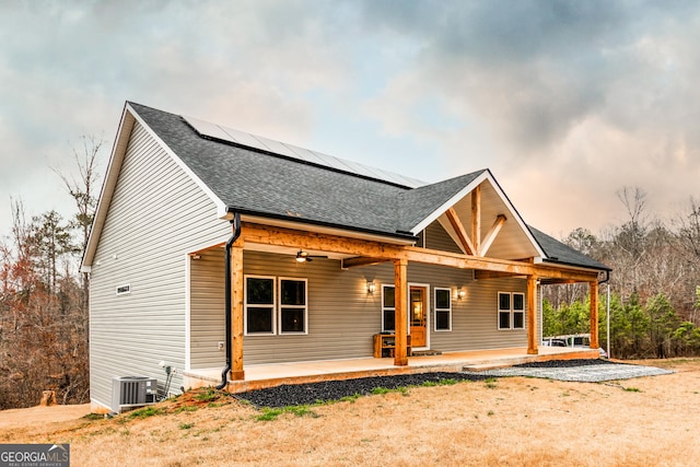 view of front of house featuring a patio area, solar panels, and a ceiling fan