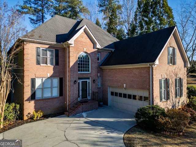 view of front of property with a garage, brick siding, roof with shingles, and driveway