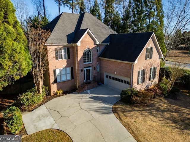 view of front of house featuring brick siding and concrete driveway