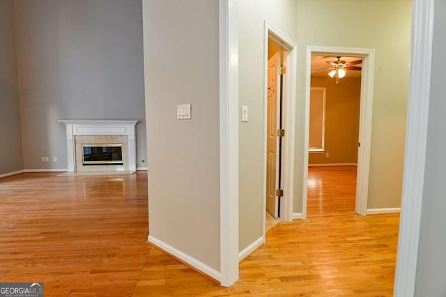 hallway featuring light wood-style flooring and baseboards