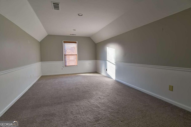 bonus room featuring visible vents, carpet flooring, baseboards, and vaulted ceiling