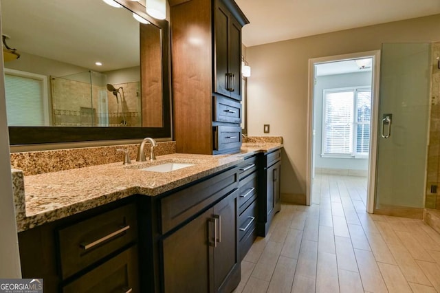 full bath with baseboards, a stall shower, and vanity