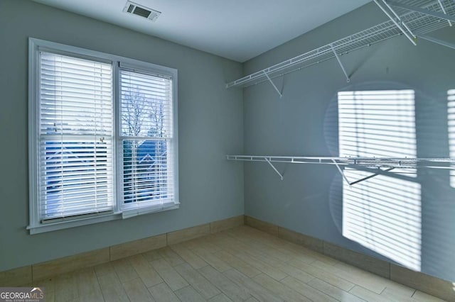 spacious closet featuring visible vents and wood finished floors