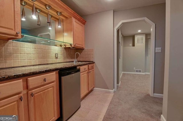 kitchen with visible vents, dark stone countertops, decorative backsplash, light colored carpet, and dishwasher