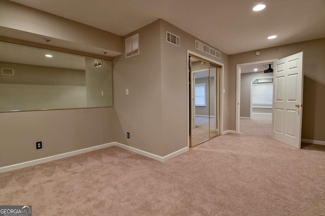 carpeted empty room featuring visible vents, recessed lighting, and baseboards