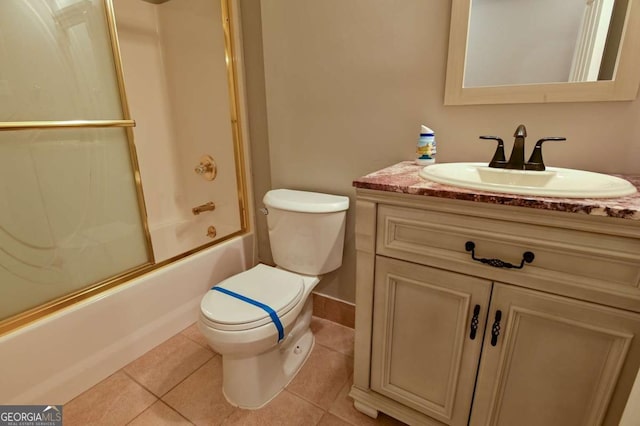 bathroom with tile patterned floors, toilet, enclosed tub / shower combo, baseboards, and vanity