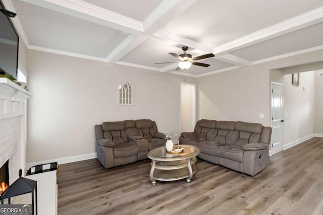 living room featuring coffered ceiling, a fireplace, and wood finished floors