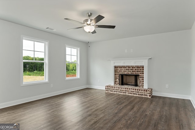 unfurnished living room featuring baseboards, visible vents, a ceiling fan, dark wood-type flooring, and a fireplace