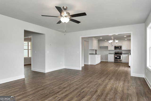 unfurnished living room with dark wood-style floors, recessed lighting, baseboards, and ceiling fan with notable chandelier