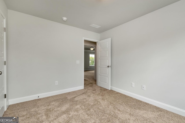 carpeted empty room with baseboards