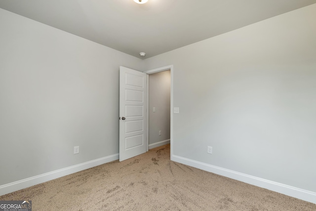 spare room featuring carpet floors and baseboards