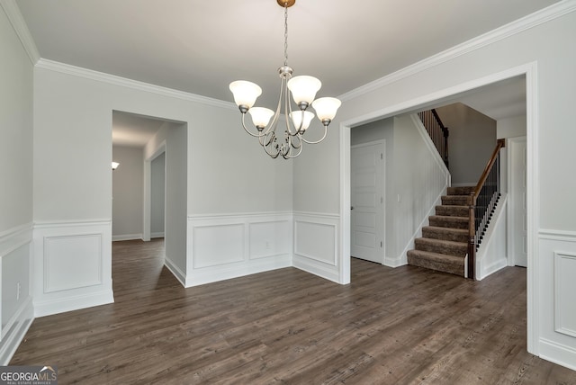 unfurnished dining area featuring a notable chandelier, dark wood finished floors, a decorative wall, stairway, and ornamental molding