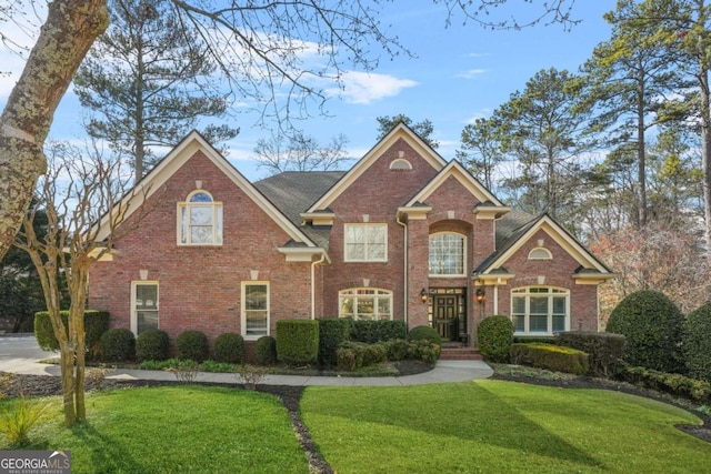 traditional-style house with brick siding and a front lawn