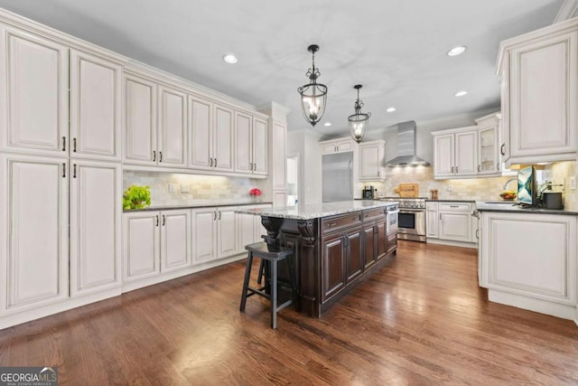 kitchen with wall chimney exhaust hood, stainless steel range, dark wood finished floors, and a center island