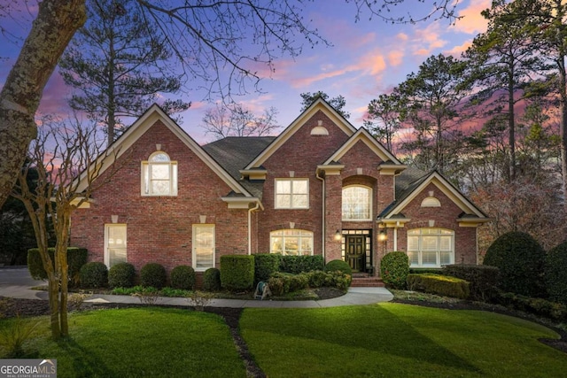 traditional home with a yard and brick siding