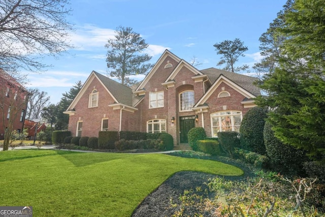 view of front of property featuring brick siding and a front lawn