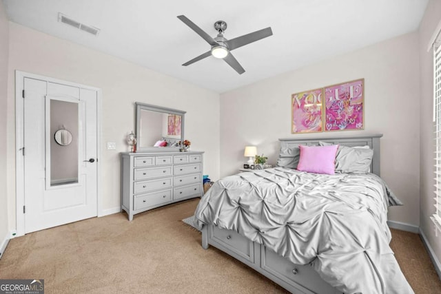 bedroom with ceiling fan, visible vents, baseboards, and light colored carpet