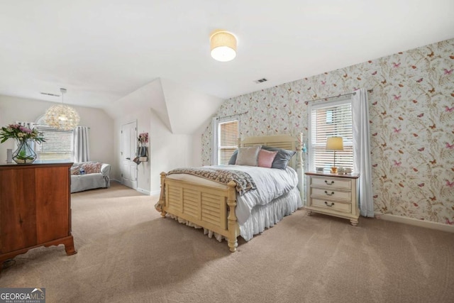 bedroom with lofted ceiling, light colored carpet, visible vents, baseboards, and wallpapered walls