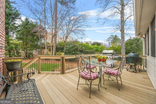 wooden deck with outdoor dining space and grilling area