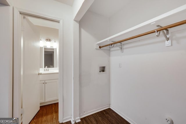 laundry area featuring laundry area, baseboards, dark wood-style floors, washer hookup, and a sink