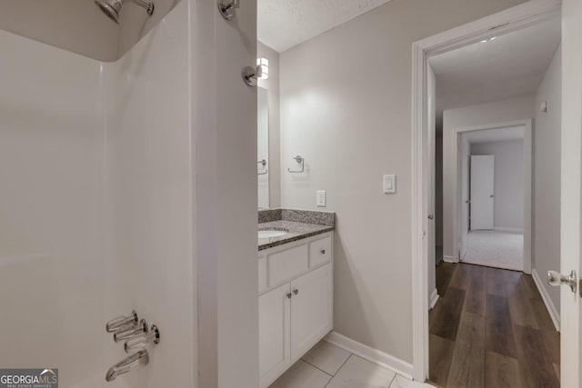 bathroom featuring vanity, baseboards, and wood finished floors