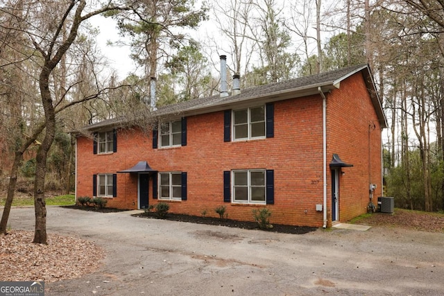 colonial inspired home with brick siding and central air condition unit