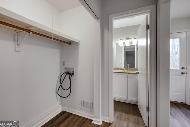 laundry room featuring dark wood-type flooring, washer hookup, a sink, and visible vents