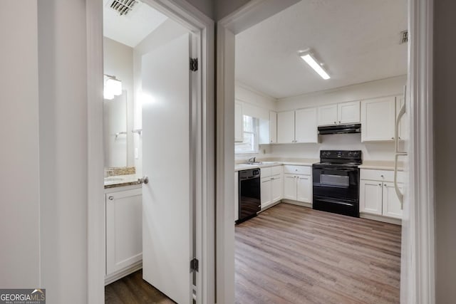 kitchen featuring light countertops, visible vents, white cabinetry, under cabinet range hood, and black appliances