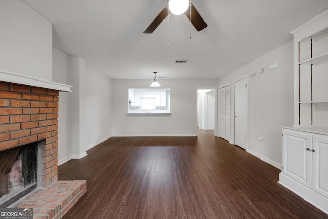 unfurnished living room with a ceiling fan, a brick fireplace, baseboards, and wood finished floors