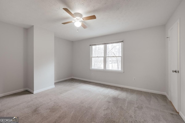 unfurnished bedroom featuring a textured ceiling, carpet flooring, a ceiling fan, and baseboards