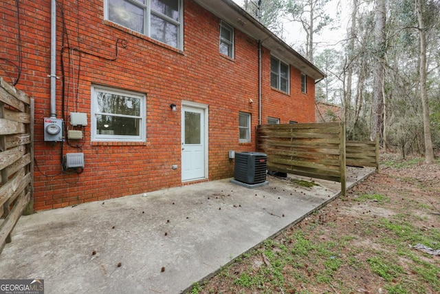 back of house featuring brick siding, a patio area, cooling unit, and fence