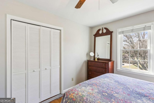 bedroom featuring ceiling fan, a closet, and baseboards