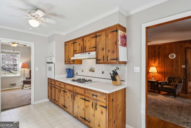 kitchen featuring white appliances, visible vents, brown cabinets, crown molding, and under cabinet range hood