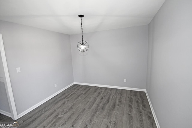 unfurnished dining area with wood finished floors and baseboards