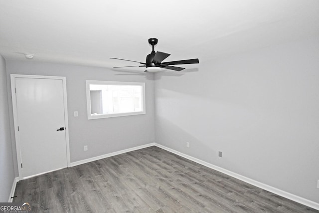 unfurnished room featuring baseboards, wood finished floors, and a ceiling fan