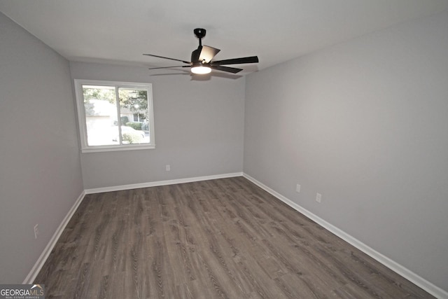 spare room with dark wood-style floors, baseboards, and ceiling fan