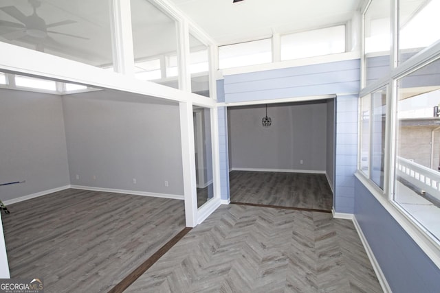 unfurnished sunroom with ceiling fan