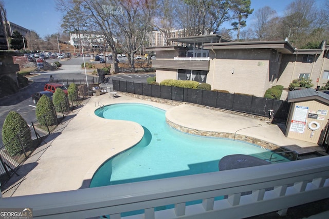 pool with a patio area and fence