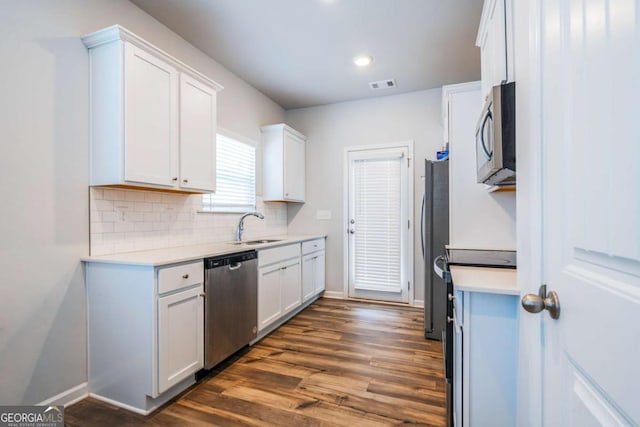 kitchen featuring visible vents, white cabinets, dark wood-type flooring, stainless steel appliances, and a sink