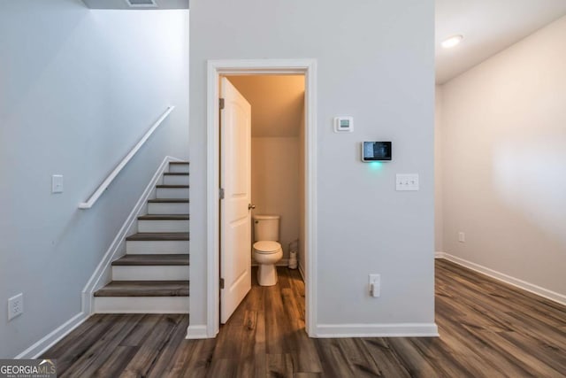 staircase featuring wood finished floors, visible vents, and baseboards